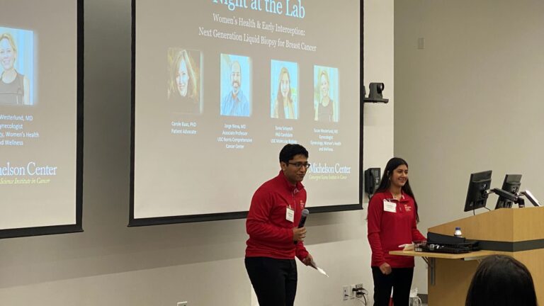 presenters in red fleece jackets presenting a slide deck