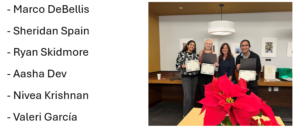 Left to right, a male student, a female faculty, and two female students pose for the camera. The students are holding award certificates.