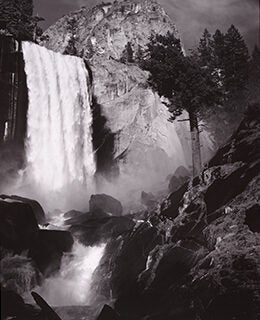 Black and white photo of a waterfall on an mountain.