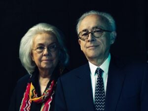 Hanna Damasio stands to the left of and just behind Antonio Damasio against a black background
