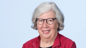 Headshot of Helen Berman wearing a zippered red jacket against a white background