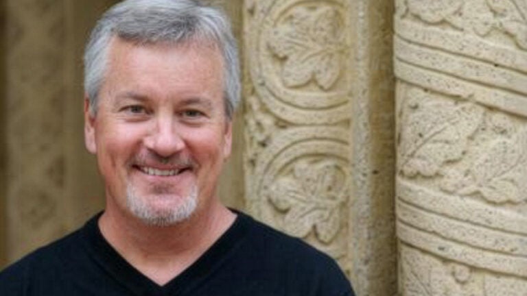 Lowell Stott headshot in front of ornate columns