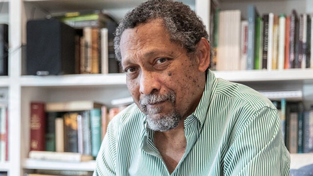 Percival Everett sits in front of a book case