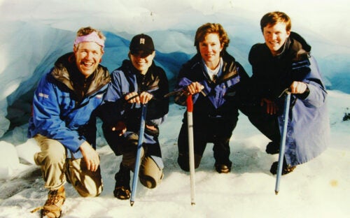 The Gauntt family dressed in cold-weather gear smile while kneeling together in glacial snow and ice