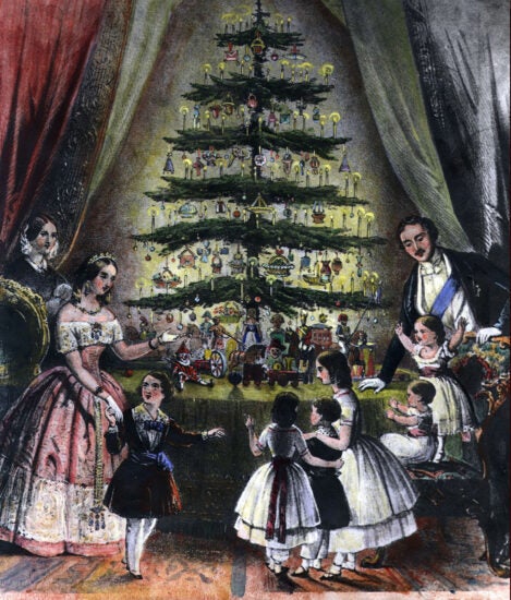 A family in Victorian clothes gathers around a Christmas tree on a table with toys underneath