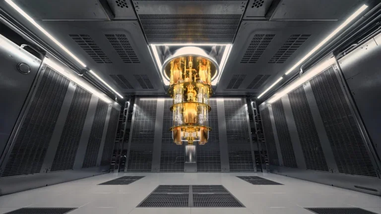 A large clean gray room with only a single gold quantum computer in the center.