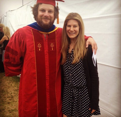 Luka Jones in graduation cap and gown with his arm around his sister