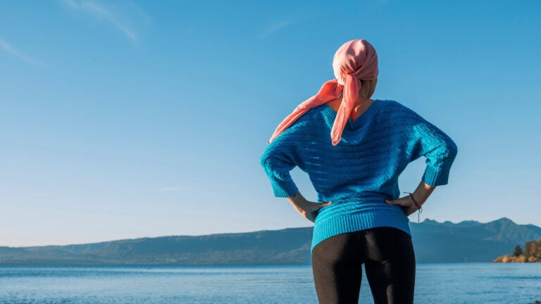 A person wearing a head wrap looks at the serene coastal scenery