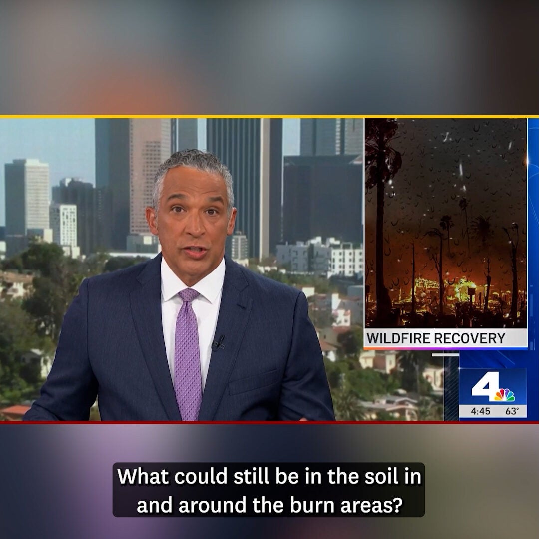News anchor sits at desk with video images behind him