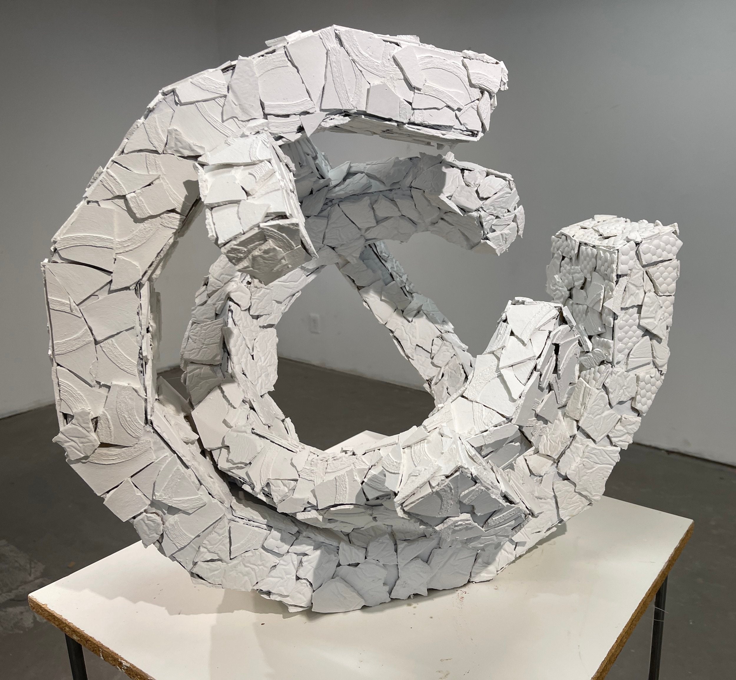 White plaster and cardboard sculpture viewed from the front.