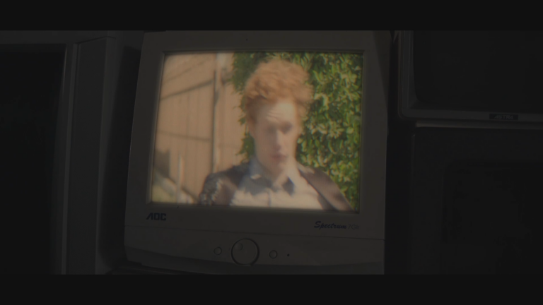Old TV with the image of a person with ginger, curly hair