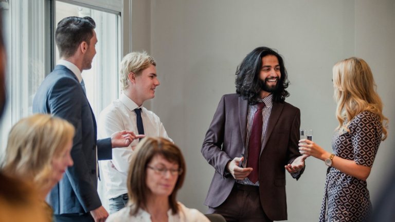 A photo of 4 people in a group talking - making an impression at a networking event