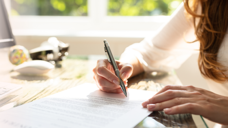 Cropped female writing on paper