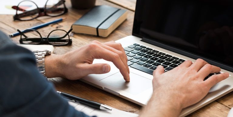 Cropped hand typing at the computer