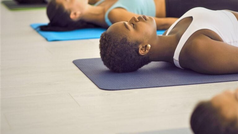 A photo of a person resting on their back on a Yoga Mat