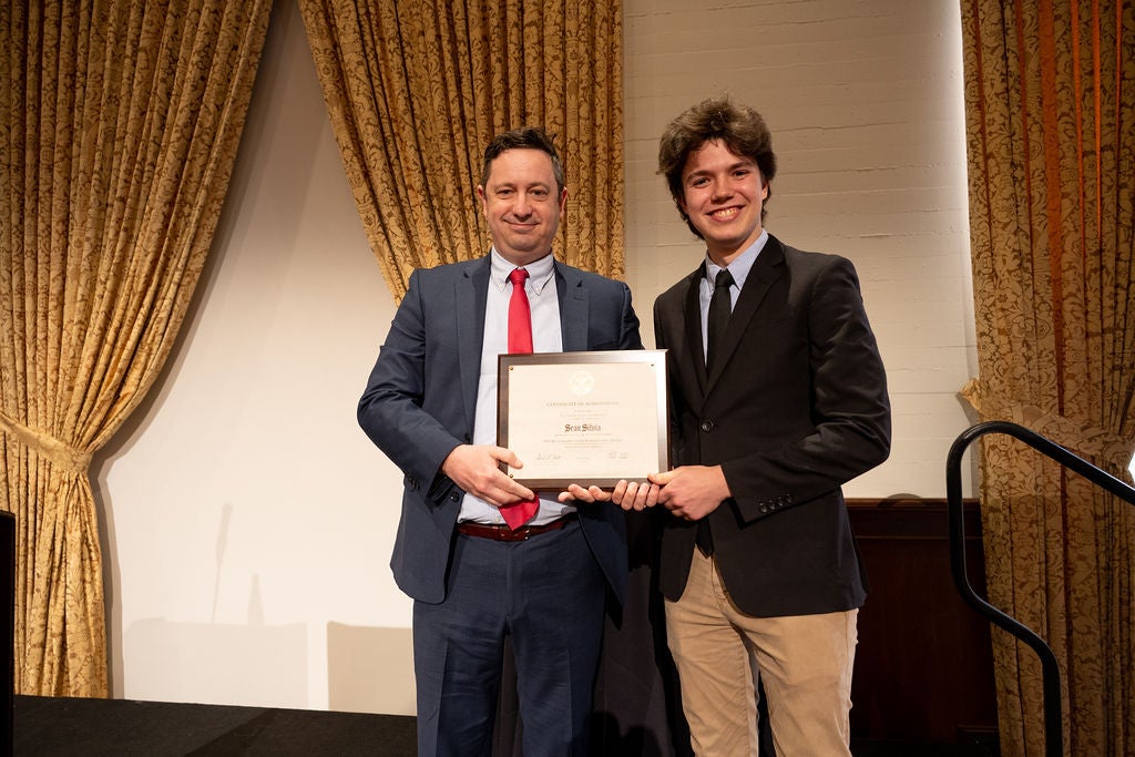 22022 Phi Beta Kappa President, Andrew Stott, presenting undergraduate award to recipient, Sean Silvia. Both are smiling.