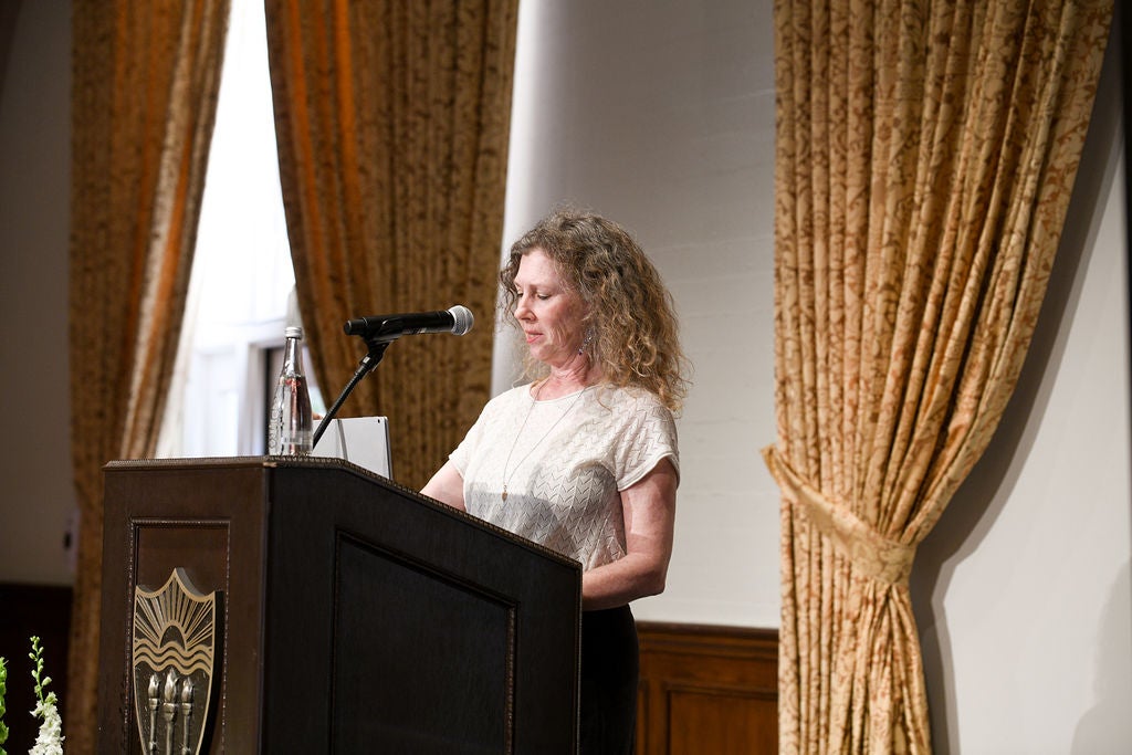 Executive Board member, Margaret Russett, standing at podium.