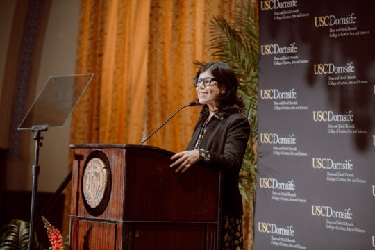 Keynote Speaker Natalia Molina at podium. Side view