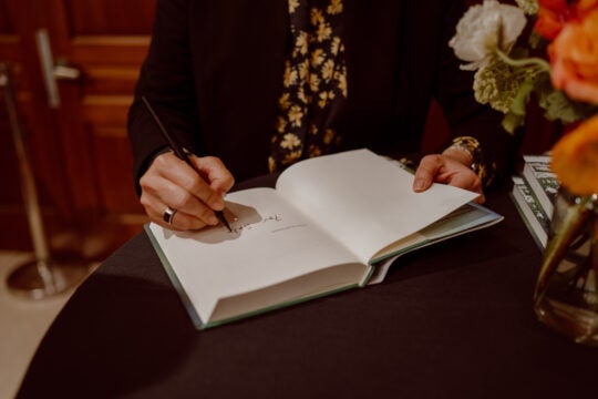 Close-up of book being signed by keynote speaker.