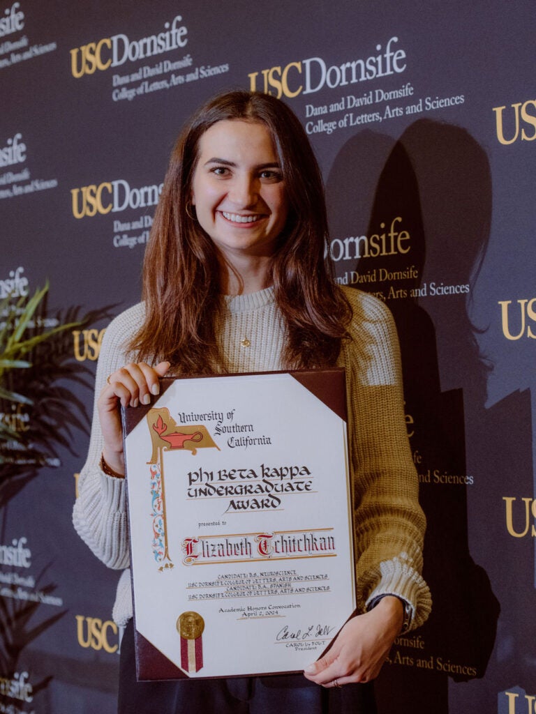 Award Recipient Elizabeth Tchitchkan smiling and holding award certificate.