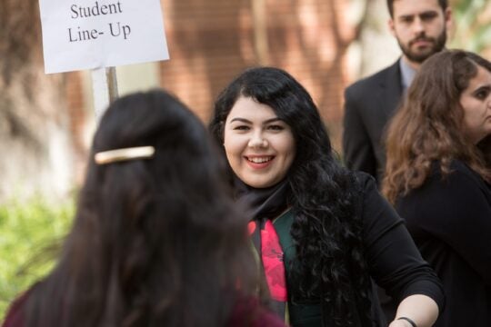 Students line-up to enter Town and Gown. Close-up of students. Sign 