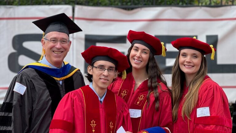 Graduating PhD Students with cap and gown