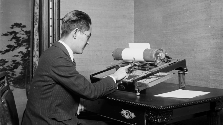 1923 black and white Harris & Ewing photograph of a man operating a Japanese-language typewriter.