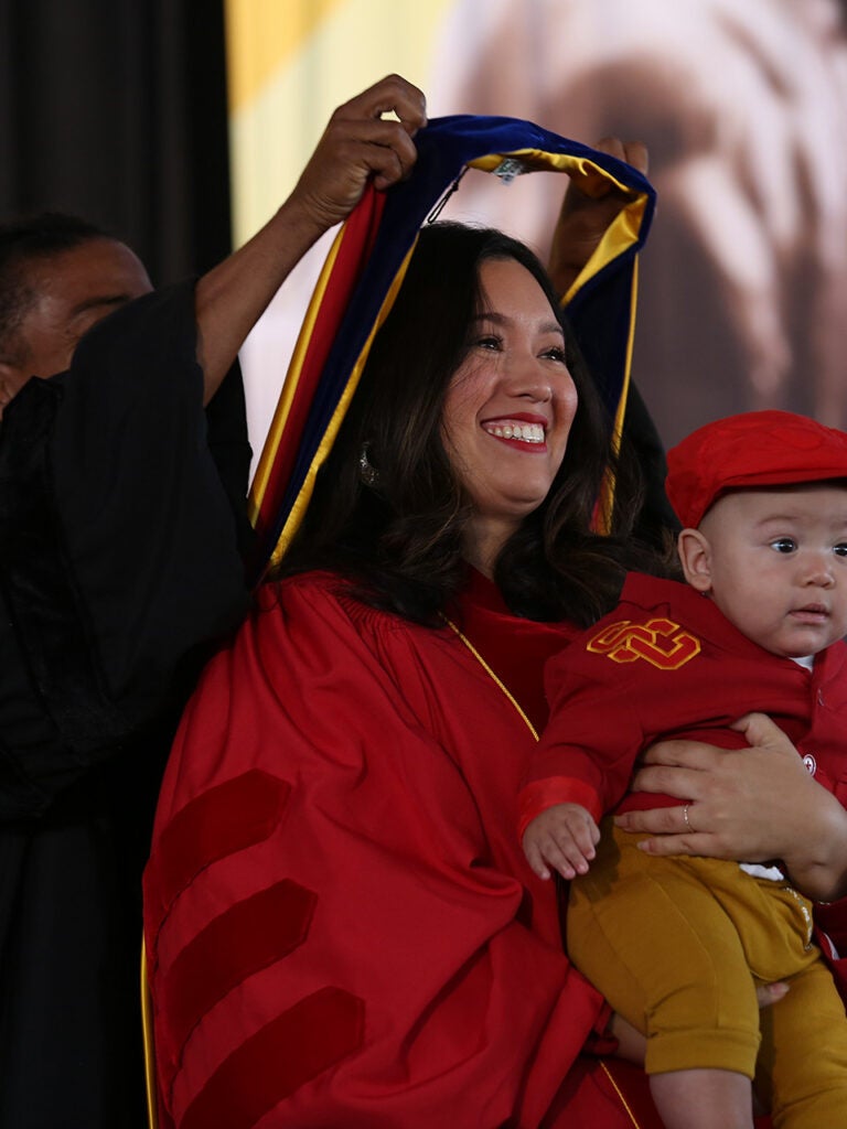 Hooding of Ph.D. graduate holding baby