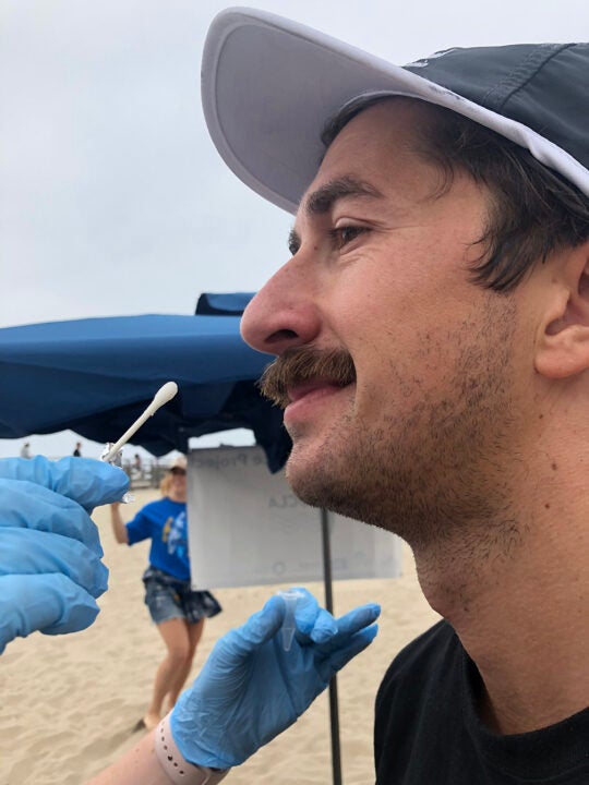 USC Sea Grant Funded Researcher Jay swabbing the nose of a surfer to test for antibiotic resistant bacteria