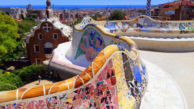 Park Güell in Barcelona, Spain showing colorful mosaic wall during the summer midday