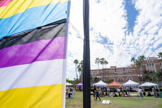 a pride flag waves in wind on USC campus