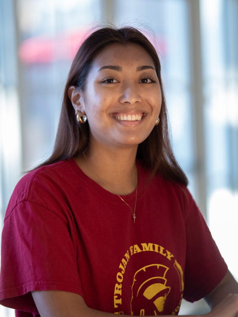 Portrait of Isabella wearing red shirt and smiling at camera