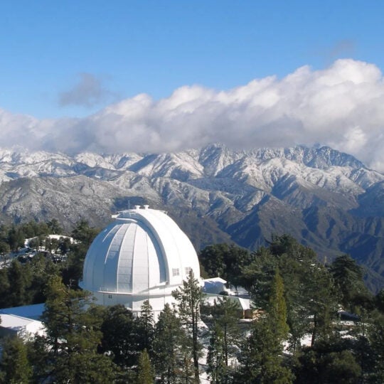 Mount Wilson Observatory with mountain range in the background and clouds