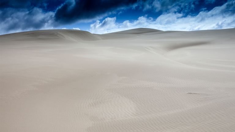 Image of sand dunes and darkening sky