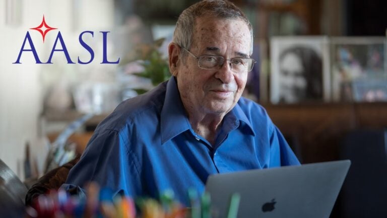 Professor Arieh Warshel in his office with the AASL logo superimposed on the image