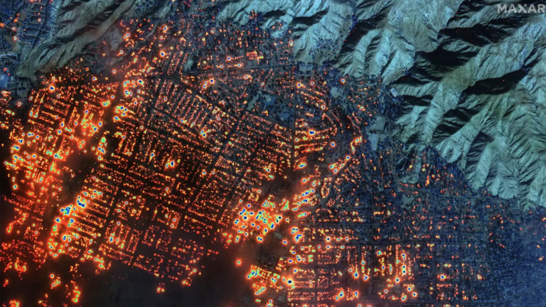 A nighttime satellite image shows wildfire burning homes and buildings in Los Angeles County’s Altadena region on Jan. 8, 2025.