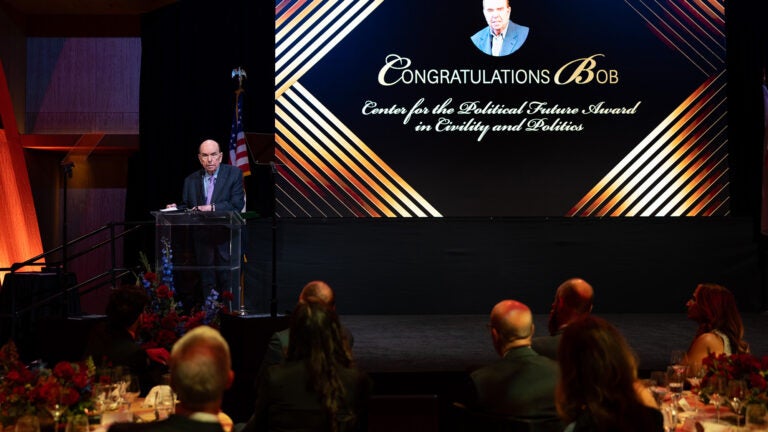 Bob Shrum stands at a podium. Behind him is a screen with the text: Congratulations Bob, Center for the Political Future Award for Civility and Politics.