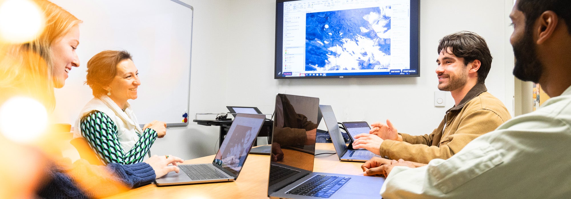 group of students and faculty discussing over computers