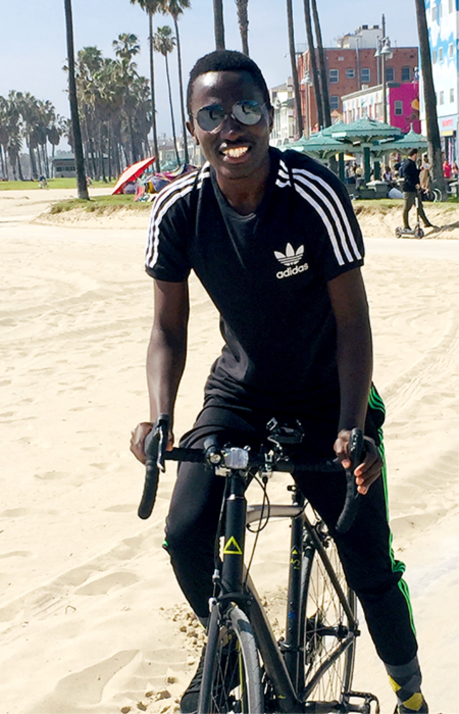 Photo of Robert Nshimiyimana on a bike at the beach