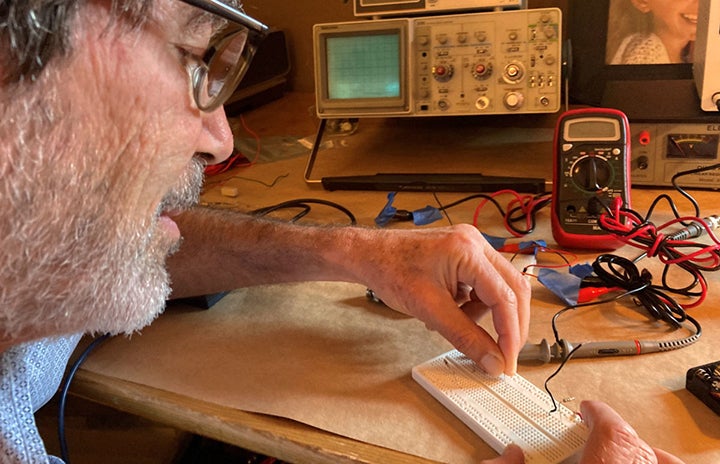 Man connecting wire to a breadboard.