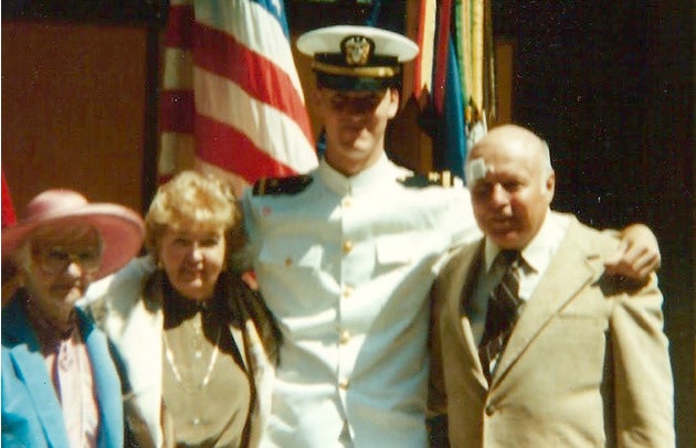 Isleib stands with his parents and an unidentified woman. An American flag is in the background.