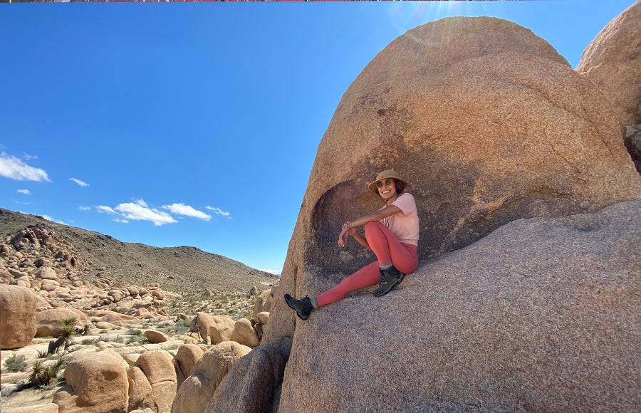 Photo of Abbie Menendez sitting on a boulder