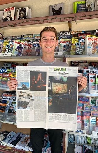 A photo of Tyler Schiffman holding up a newspaper.