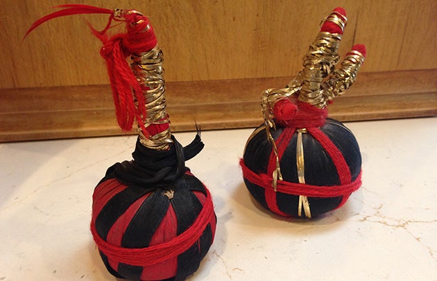 Two spheres wrapped in black and red with protrusions on the top wrapped in gold wire.