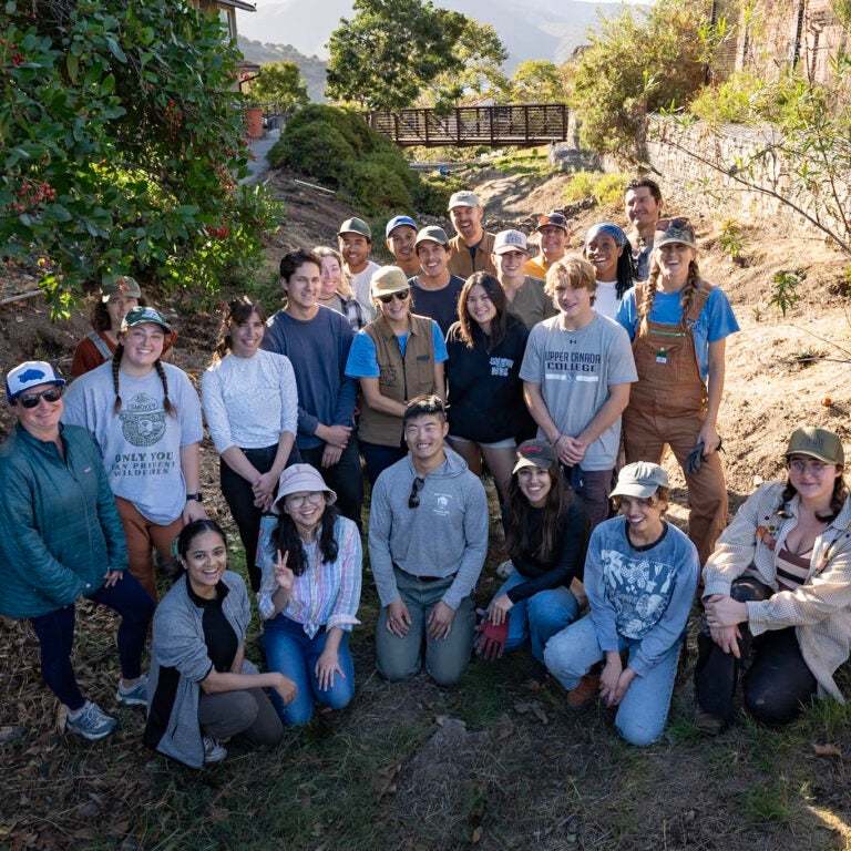 a group of Wrigley Institute staff and faculty, USC students, and community volunteers stands in the ravine on the Wrigley Marine Science Center campus, where they planted native plants to help restore the ecosystem