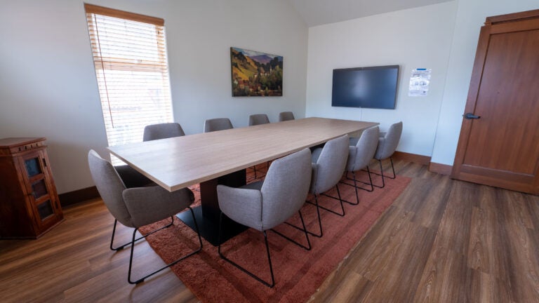 a boardroom with comfortable armchairs and an orange rug