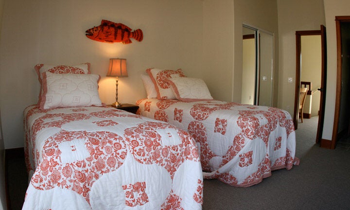a bedroom with two twin beds covered in pretty red-and-white quilts
