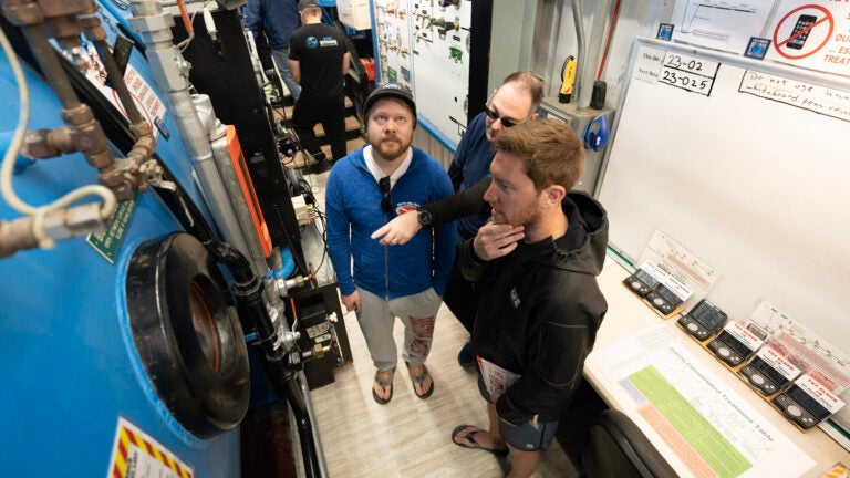A person points as others listen near a hyperbaric chamber