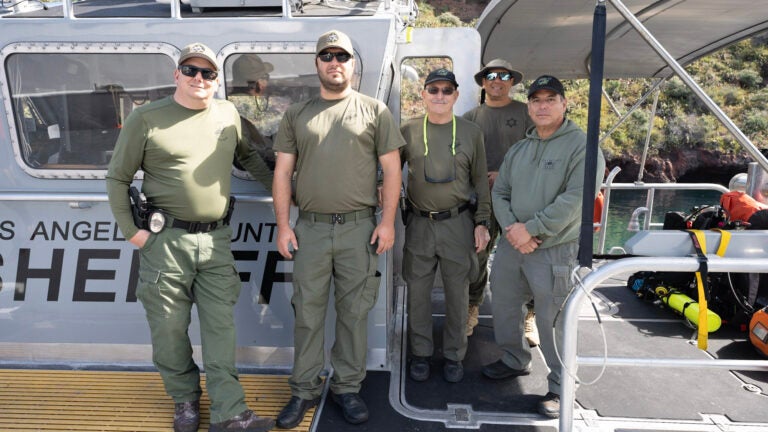 5 sheriffs stand posed on a boat docked at Wrigley Marine Science Center on Catalina Island