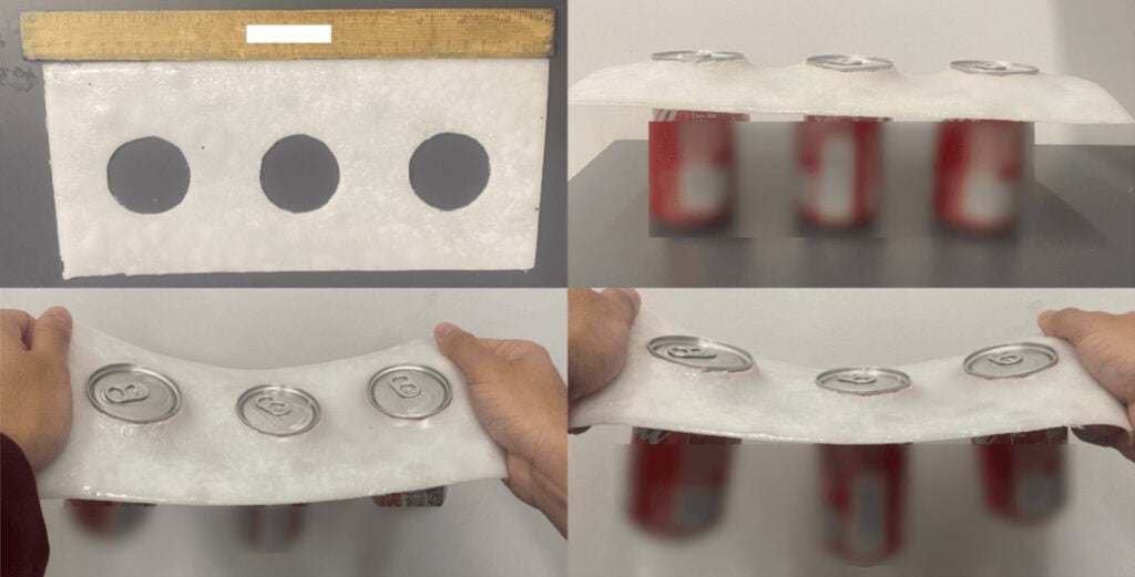 a white plastic substitute, made from a mineral found in seashells, is shown next to a ruler and holding three red cans of soda
